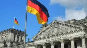 German flag fluttering in front of a neoclassical government building with columns